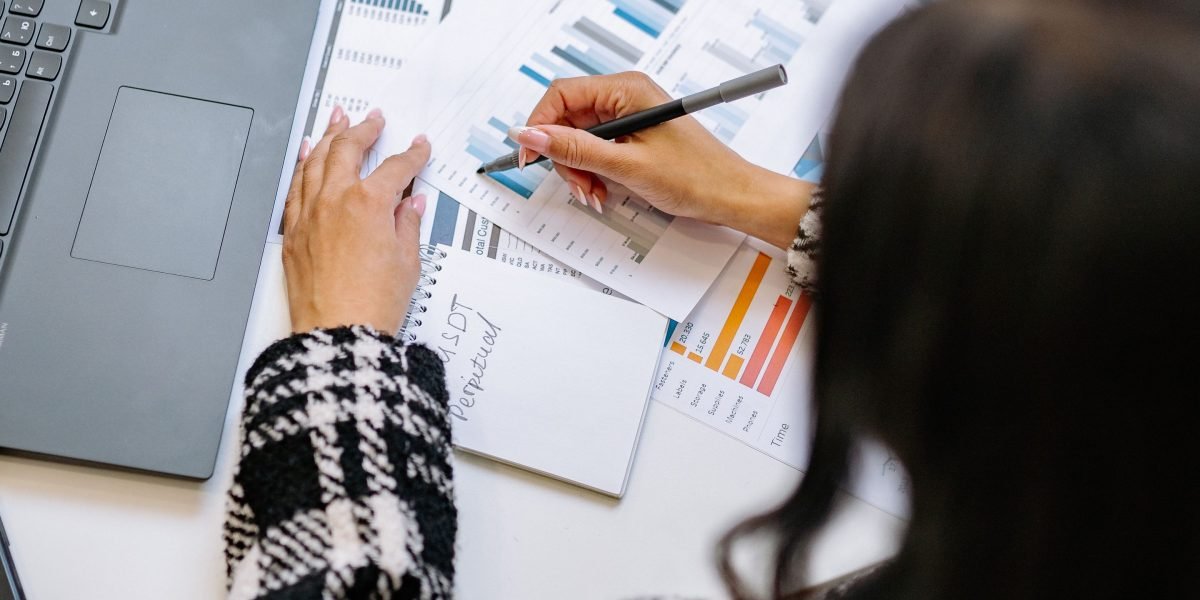 A professional examines charts and data, illustrating the core data analysis workflows with Python libraries like Pandas and NumPy.