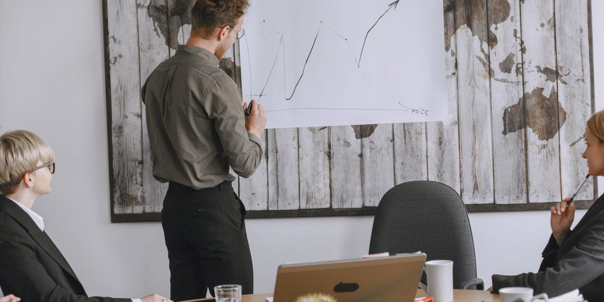 A diverse group of business leaders in a formal meeting setting, actively engaged in a discussion about market trends and competitive landscapes.