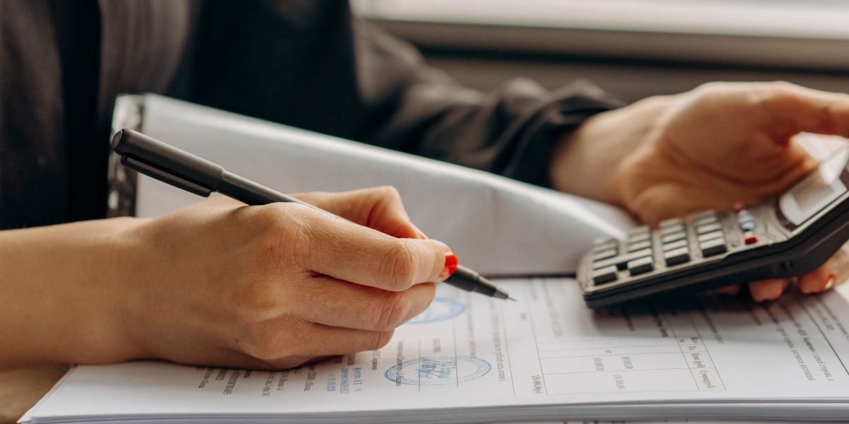 A person at a desk reviewing financial documents or a spreadsheet, focused on budget and return on investment.
